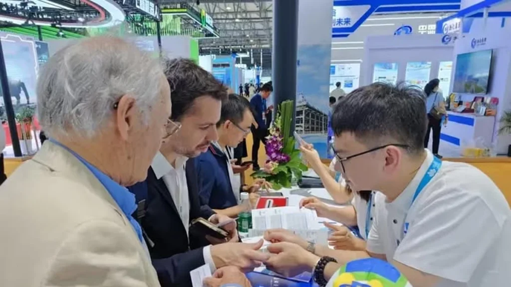 About Us Xianghui Pack representative reviewing product information with international customers at a trade show