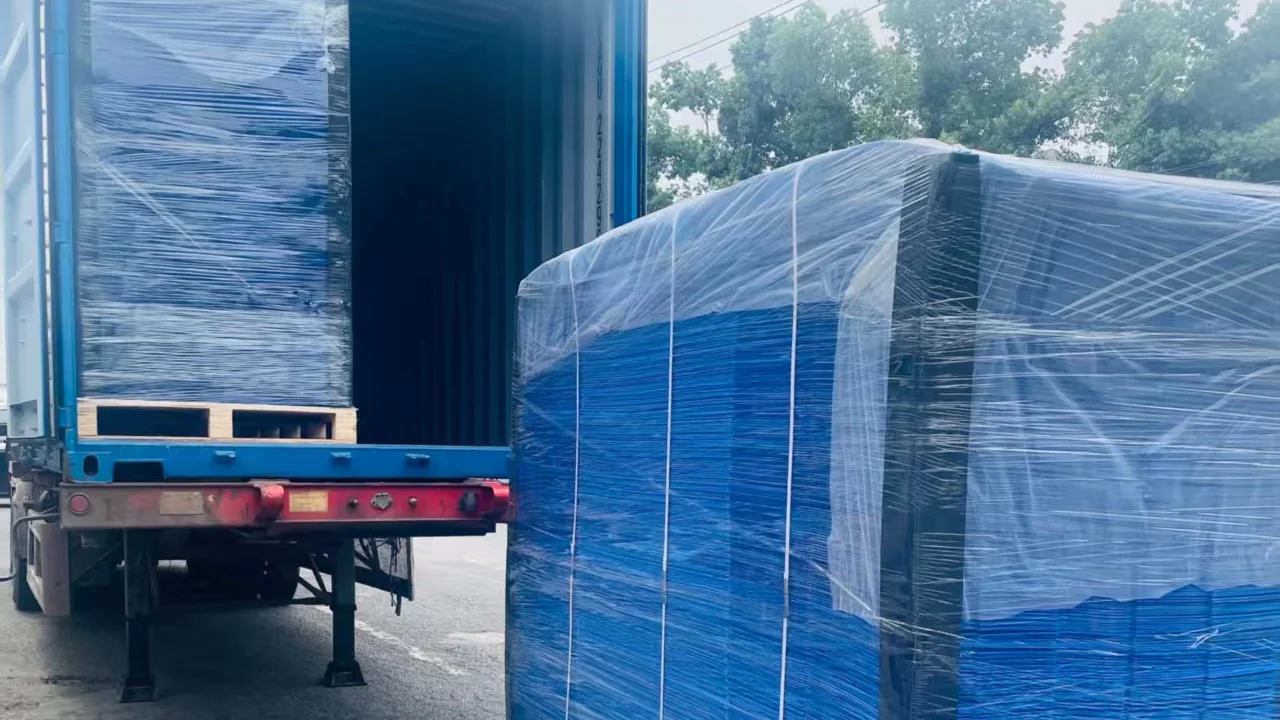 Palletized PP corrugated plastic boxes beside an open shipping container