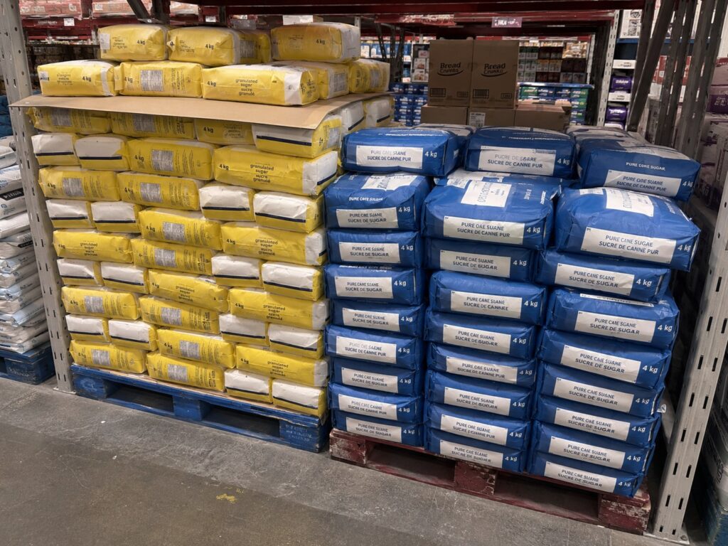 Yellow and blue 4 kg sugar bags stacked on pallets in a warehouse