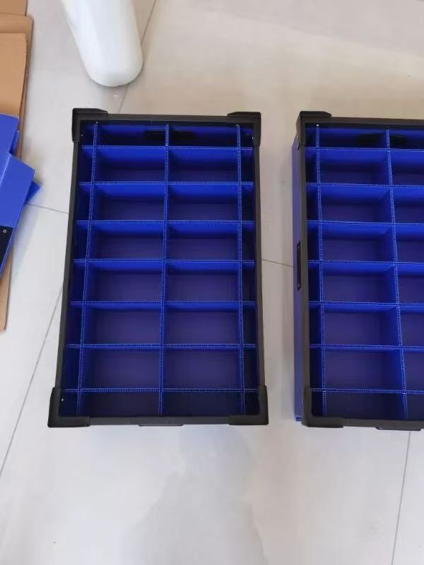 Two dark trays fitted with blue corrugated plastic divider cells